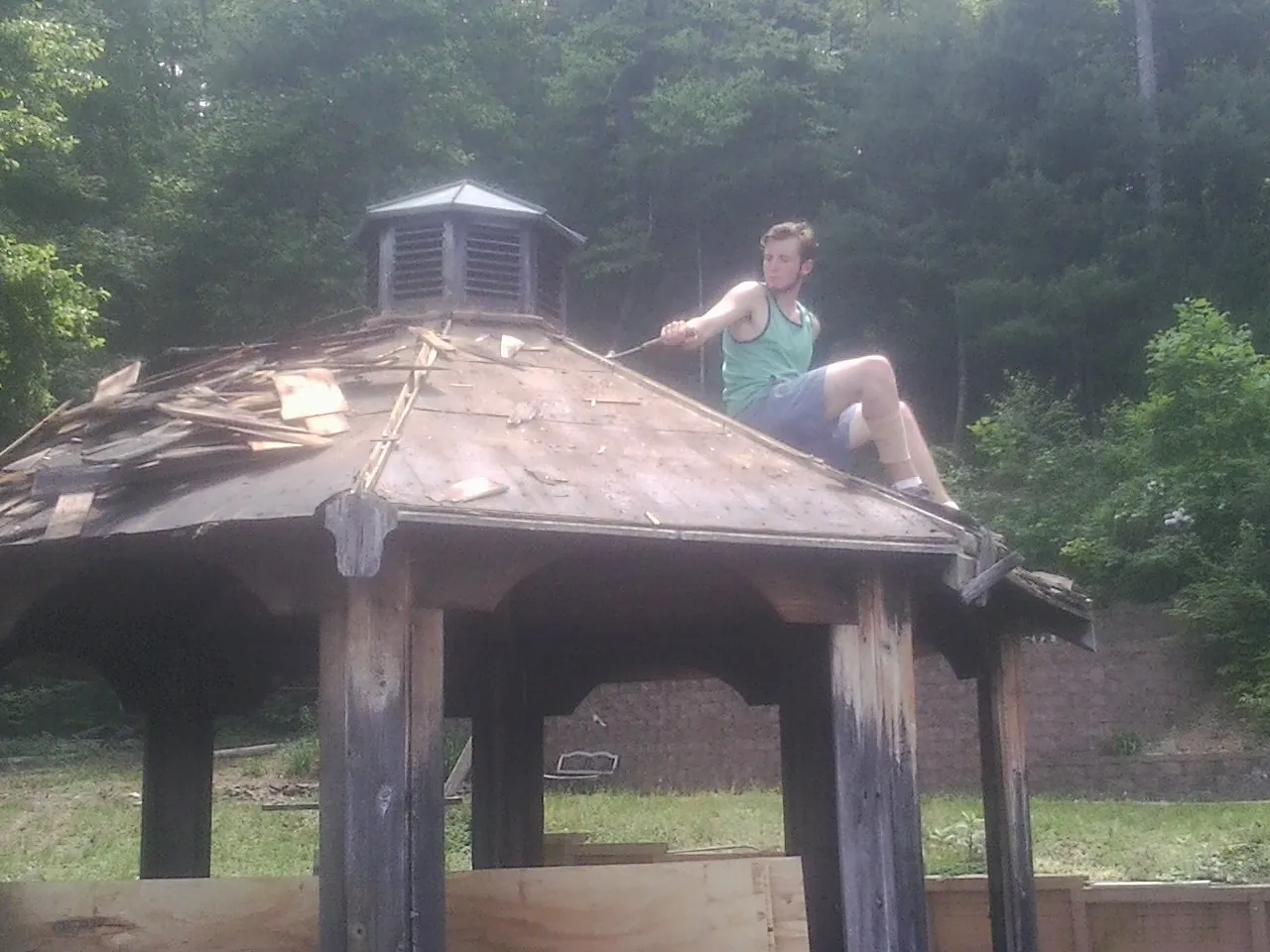 Tearing the old roof off a wooden gazebo before new shakes in Spring Glen