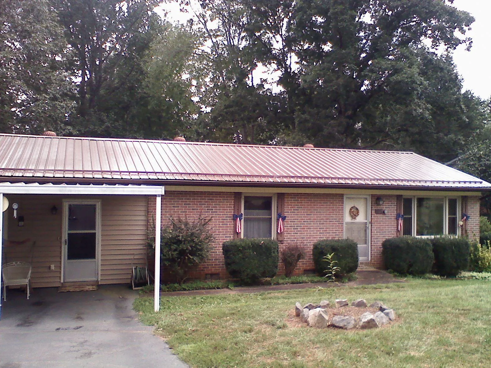 Bronze metal roof and carport on a brick ranch home — Roof Repair work by our crew in Spring Glen