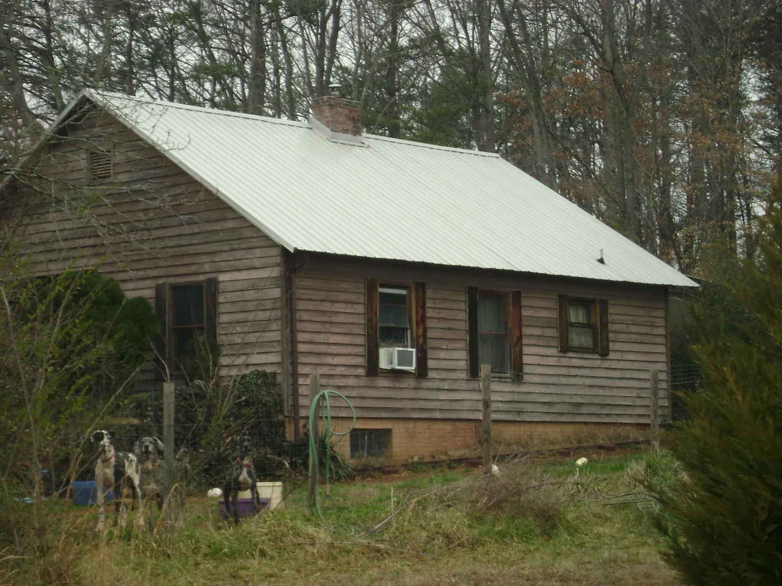 White metal roof on an old wood sided farmhouse, from a Metal Roof Installation job in Spring Glen